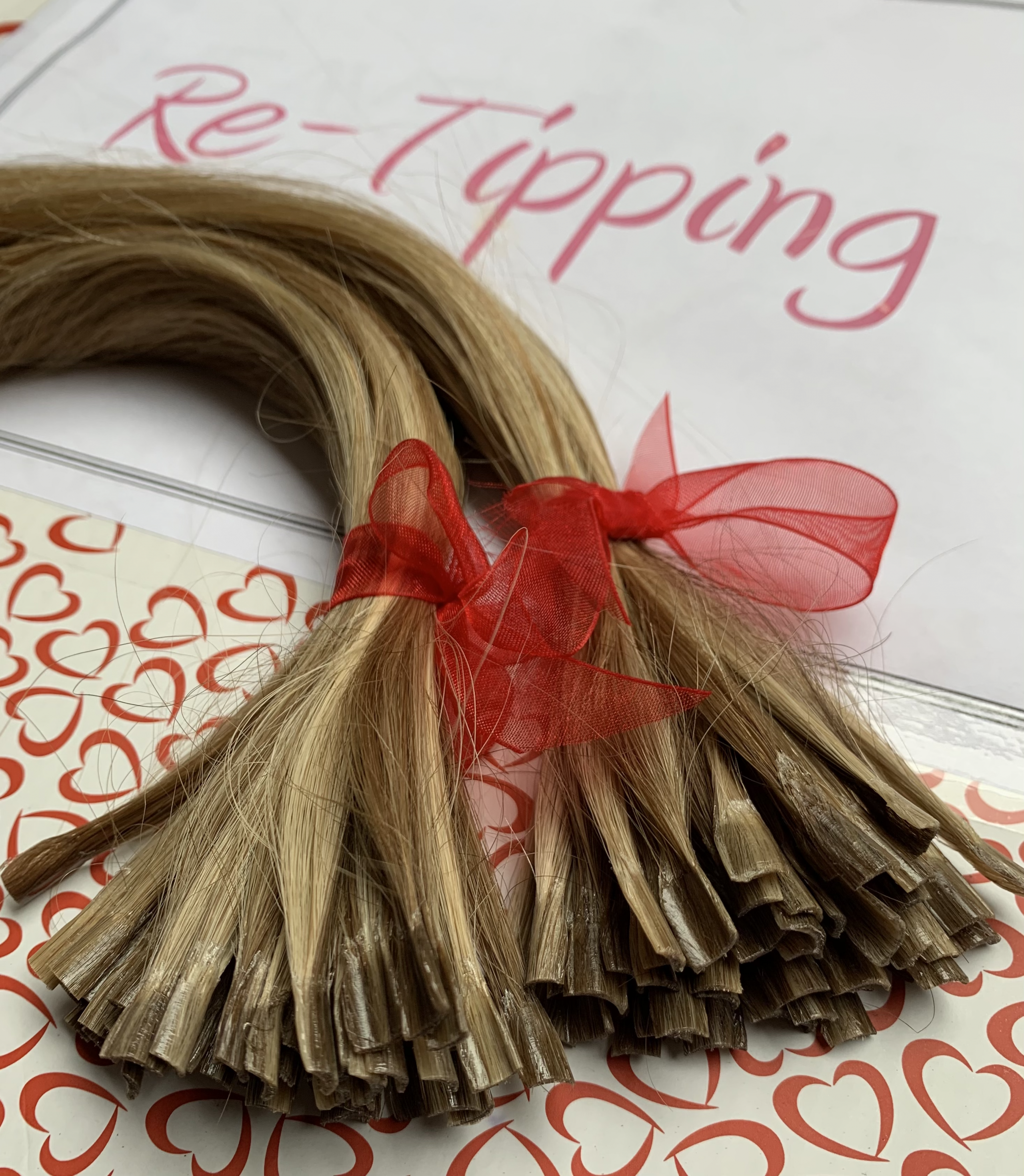 A set of retipped hair extension strands neatly arranged for reapplication.